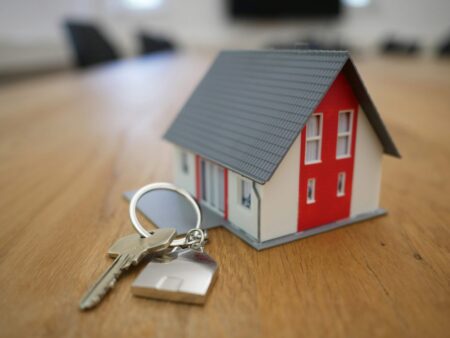 white and red wooden house miniature on brown table